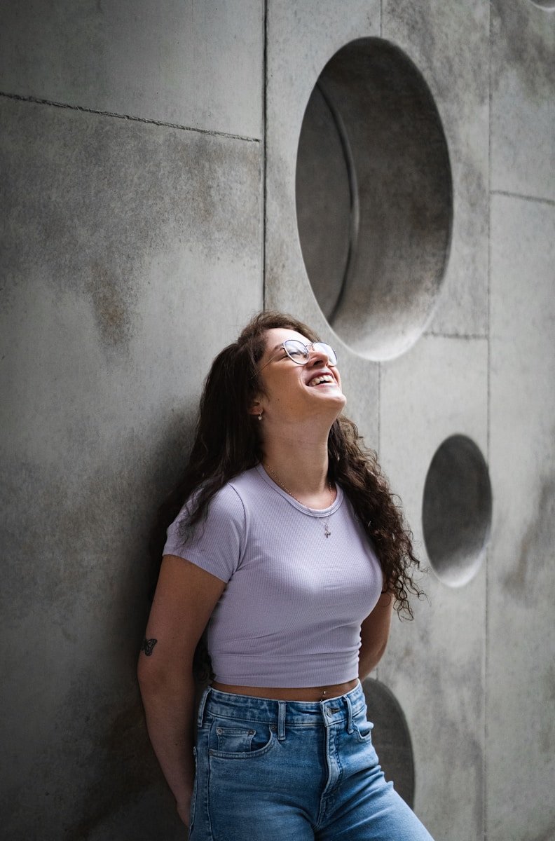 woman in white crew neck t-shirt leaning on wall